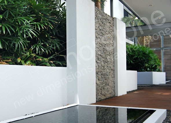 Norstone Charcoal Rock Panels used as a feature wall in a modern designed outdoor space with reflecting pond